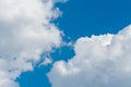 Photo of beautiful dense white clouds left and right. Blue sky in the center of the frame