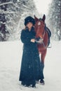 Photo of a beautiful girl in full growth in black coat, horse, w