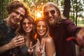 Photo of beautiful hippie people men and women, smiling and taking selfie in forest Royalty Free Stock Photo