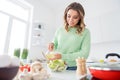 Photo of beautiful housewife hold olive oil adding to vegetable salad ingredients cooking tasty meal good mood vegan Royalty Free Stock Photo