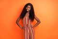 Photo of beautiful nice afro american young lady hold hands waist wear suit isolated on orange color background