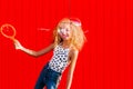 Beautiful teenage girl inflates soap bubbles against the red wall Royalty Free Stock Photo