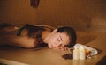 Photo of a beautiful woman in spa salon having spa therapy with coffee done by a masseur Royalty Free Stock Photo