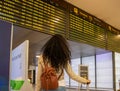 Photo of a beautiful woman traveler looking at the departure board at Adolfo Suarez Madrid-Barajas International Airport Royalty Free Stock Photo