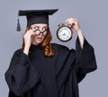 photo of beautiful young alumnus with alarm clock on the wonderful grey studio background