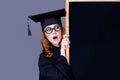 photo of beautiful young alumnus with blackboard on the wonderful grey studio background