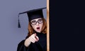 photo of beautiful young alumnus with blackboard on the wonderful grey studio background