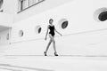 Photo of beautiful young girl with dark hair in elegant swimsuit, walking by the city street Royalty Free Stock Photo