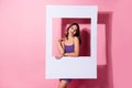 Photo of beautiful young happy woman hold frame portrait good mood isolated on pastel pink color background
