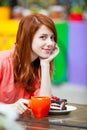 photo of beautiful young woman eating chocolate cake and drinking coffee in the cafe Royalty Free Stock Photo