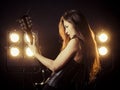 Sexy woman playing electric guitar on stage Royalty Free Stock Photo