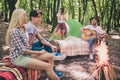 Photo of best friends happy positive smile cam-fire play guitar music song camp forest expedition rest outdoors