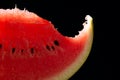 Bit slice of watermelon with seeds on black background Royalty Free Stock Photo