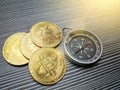 Photo of bitcoins with magnetic compass on the table.