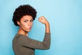 Photo of black millennial girl showing you her biceps thinking on result boasting about her strength isolated over vivid