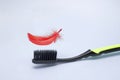 A photo of the black toothbrush and a red feather above it. Periodontitis, gingivitis, bleeding gums, hygiene photo of periodontal