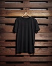 Photo of black tshirt holding on wood background