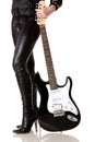 Guitar next to female legs in leather leggings