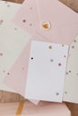 Photo of Blank white card in pink envelope isolated woodden color background with glitter stars, vaucher, gift certificate. White Royalty Free Stock Photo