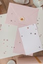 Photo of Blank white card in pink envelope isolated woodden color background with glitter stars, vaucher, gift certificate. White Royalty Free Stock Photo