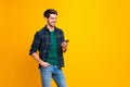 Photo of blogger guy holding telephone in hands checking subscribers wear casual checkered shirt and jeans isolated Royalty Free Stock Photo