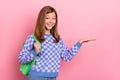 Photo of blond sweet teen girl hold empty space wear bag sweater isolated on pink color background Royalty Free Stock Photo