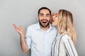 Photo of blonde woman in casual clothing screaming in ear of excited man Royalty Free Stock Photo