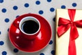 Photo of blue cup of coffee and cute gift on the white dotted ba Royalty Free Stock Photo