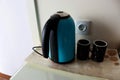 Photo of a blue electric kettle and two black cups or mugs for coffee Royalty Free Stock Photo