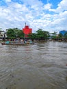 Photo of a boat carrying tourists down the Martapura river in Banjarmasin, Indonesia