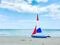 Photo of boat with colorful sails on white sand beach at cloudy weather in north Germany Royalty Free Stock Photo