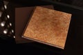 Photo book with a cover of genuine leather. Brown color with decorative stamping . Dark background. Soft focus