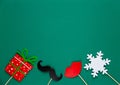 Photo booth colorful props for christmas party - red lips, snowflake, gift, moustache on green background. Christmas and New year Royalty Free Stock Photo