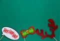 Photo booth colorful props for christmas party - santa hat, glasses, beard on green background. Christmas and New year Royalty Free Stock Photo