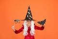 Photo booth props. Small girl in black witch hat. Autumn holiday. Join celebration. Little child in witch costume