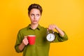 Photo of bored exhausted lady hold cup clock look empty space wear green shirt isolated yellow color background