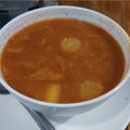 Photo of a bowl of curry soup with carrots and chili paste