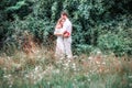 Bride and groom with a bouquet of peonies posing against the backdrop of the forest Royalty Free Stock Photo