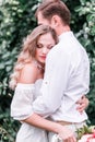 Bride and groom with a bouquet of peonies posing against the backdrop of the forest Royalty Free Stock Photo