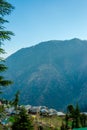 Bright sunlight shining through hole of clouds to dark scene of mountain village - India