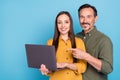 Photo of brown haired husband wife couple hold hand point finger computer isolated on blue color background