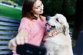 Photo of brunette on bench doing selfie with retriever Royalty Free Stock Photo