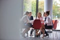 Business colleagues discussing while sitting at table in office lobby during meeting Royalty Free Stock Photo