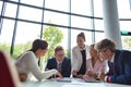 Business colleagues discussing while sitting at table in office lobby during meeting Royalty Free Stock Photo