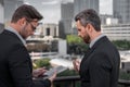 Photo of business partners talk conversation outdoor. Two handsome businessmen in suits discuss a working project Royalty Free Stock Photo