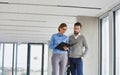 Business people reading document while standing in new empty office Royalty Free Stock Photo