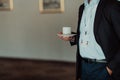 Photo of a businessman holding a cup of coffee in his hand while standing in the corridor on a short break from work Royalty Free Stock Photo