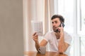 Photo of businessman with phone, papers and coffee on the table.