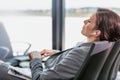 Portrait of businesswoman listening to music on smartphone while sleeping and waiting for boarding in airport Royalty Free Stock Photo