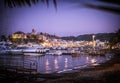 Photo of a bustling harbor filled with illuminated boats at night in Sicily's Eolie Islands